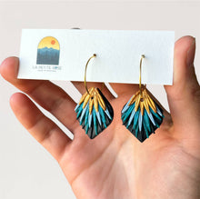 Load image into Gallery viewer, Peacock-inspired clay earrings in teal, black and gold on hoops, held on a display card.