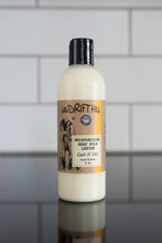 Load image into Gallery viewer, Goats N' Oats goat milk lotion bottle on a reflective surface.
